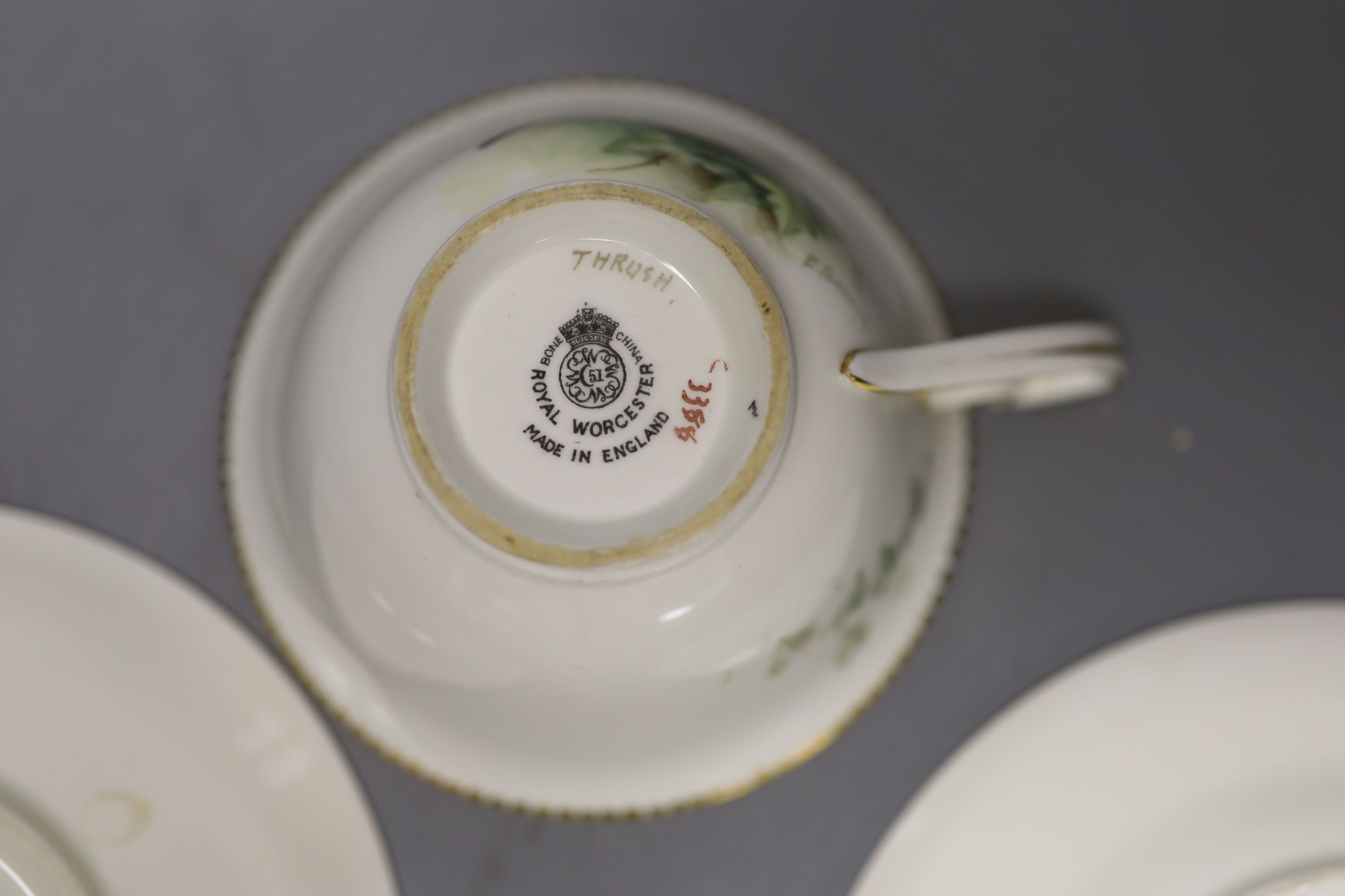 A Royal Worcester teacup, saucer and side plate, each unusually painted with a thrush on a branch by E. Townsend, signed black mark,